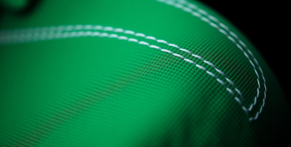 Macro detail of white stitching on green MKADO golf fabric